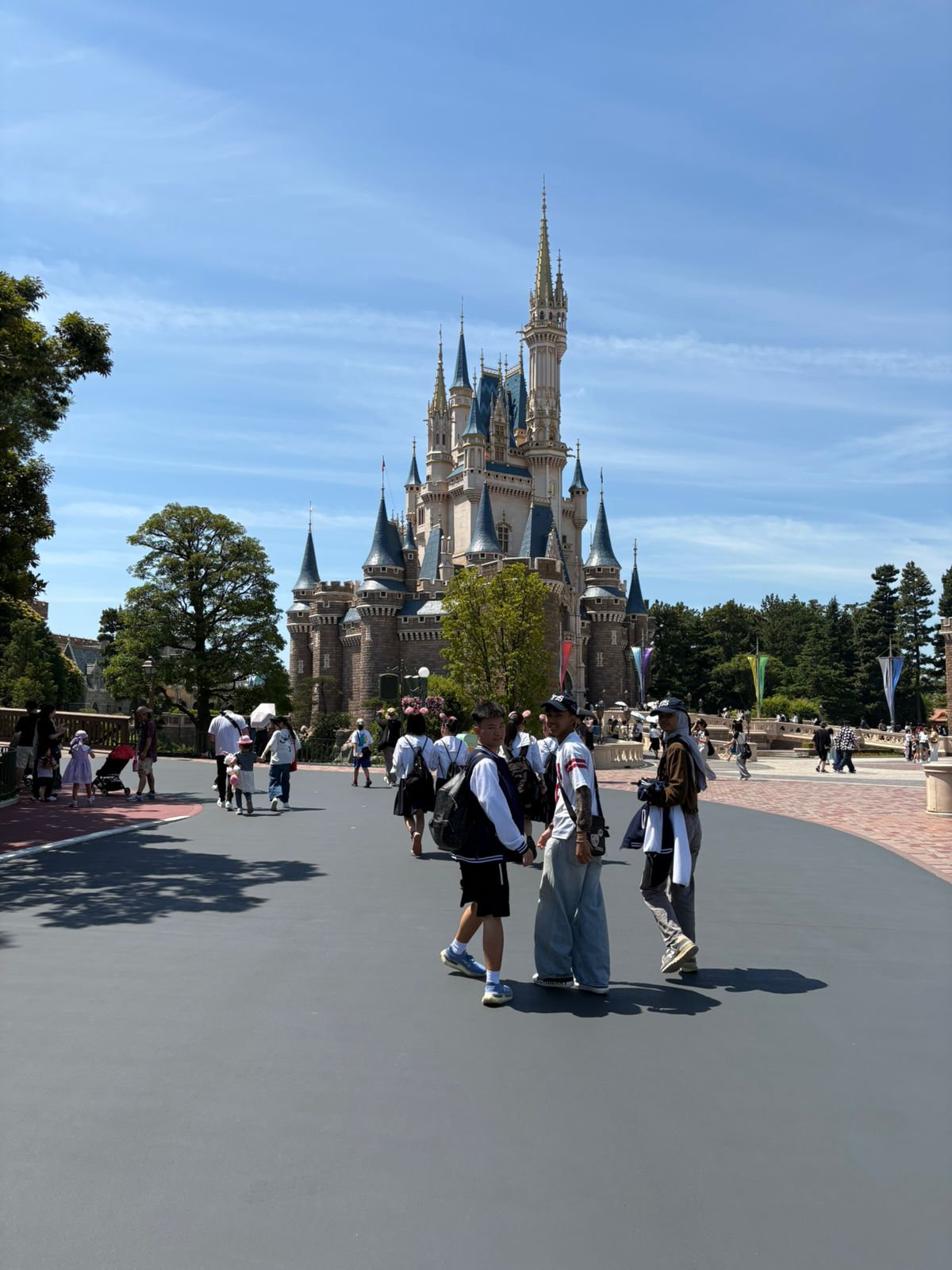 Syafa, Nevan and Felix walking near the castle at Tokyo Disneyland