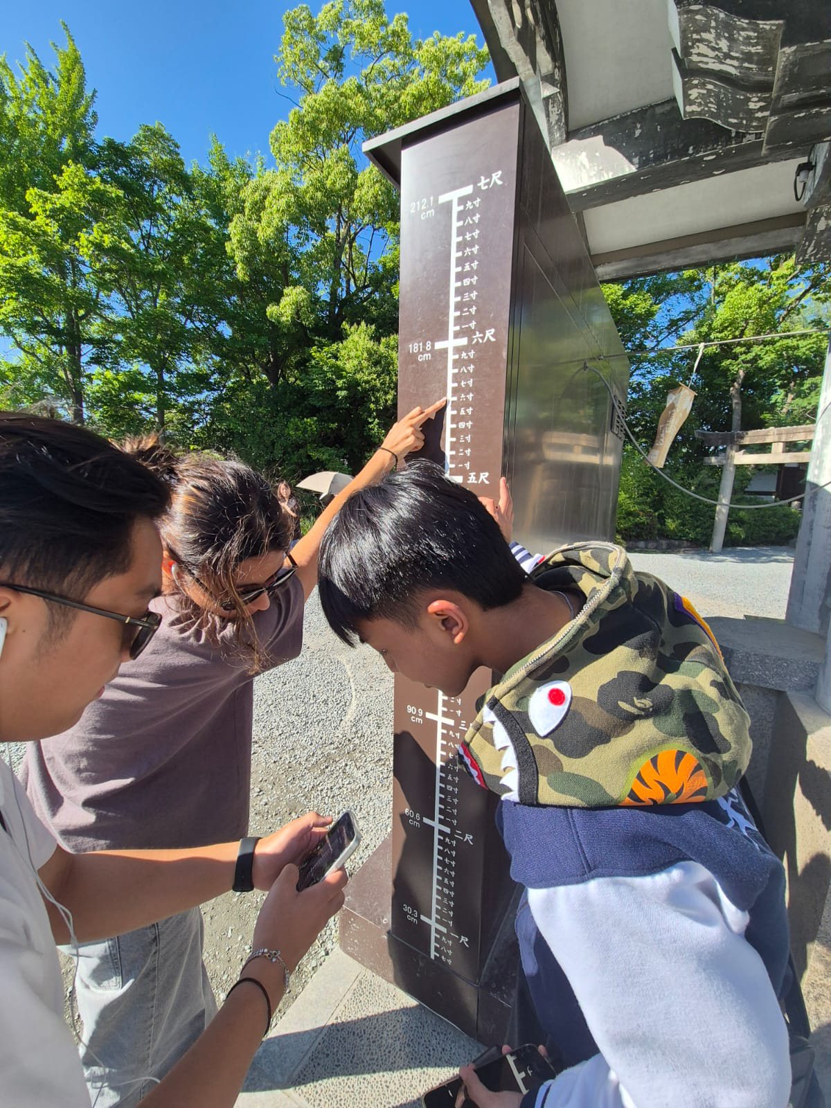 YIS students reading a height marker around Osaka Castle grounds
